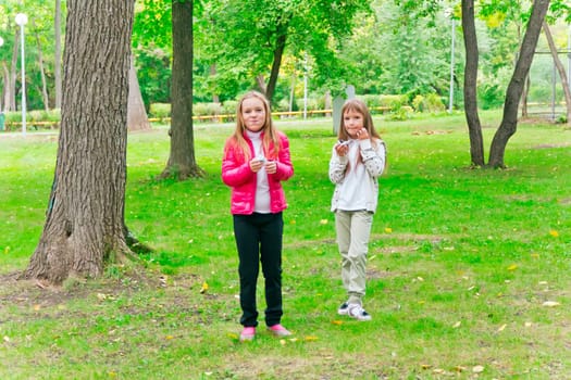 Photo of two eating girls in summer