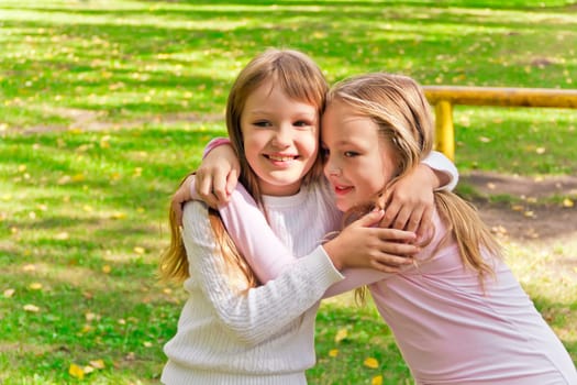 Photo of two embracing girls in summer