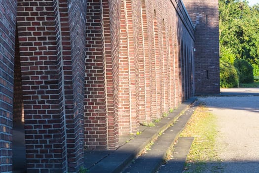 Old building with brick arches along a street.