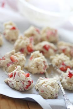Biscuit batter dropped onto parchment-covered pan