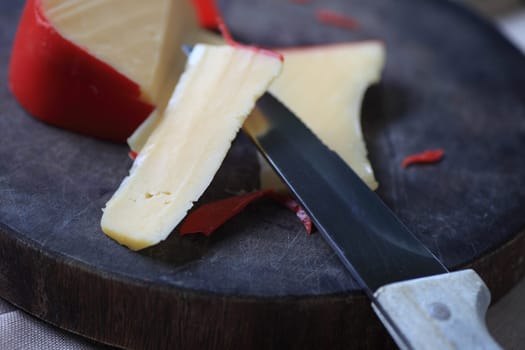 A block of cheese on a cutting board, slices cut