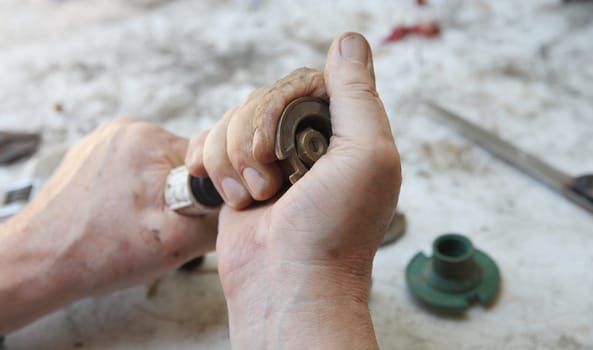 A man twists the upper portion of a sprinkler head.