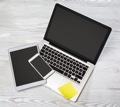 View of a Laptop in high definition with tablet and mobile on a wood background