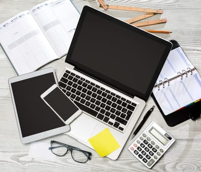 View of a Wood businessman's desk in high definition with laptop, tablet and mobile