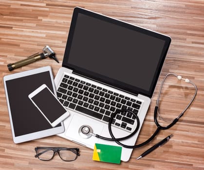View of a Wood doctor's desk in high definition with laptop, tablet and mobile phone