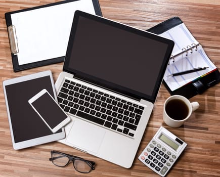 View of a Wood businessman's desk in high definition with laptop, tablet and mobile