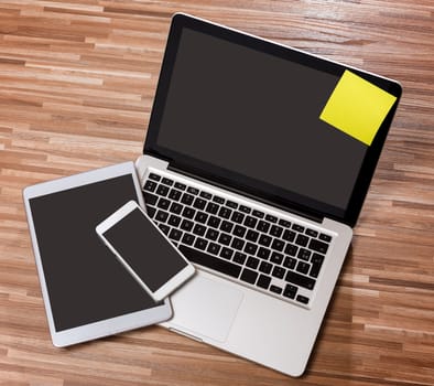 View of a Laptop in high definition with tablet and mobile phone on a wood background