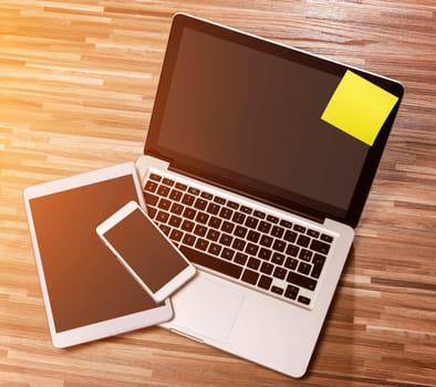 View of a Laptop in high definition with tablet and mobile phone on a wood background