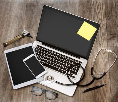 View of a Wood doctor's desk in high definition with laptop, tablet and mobile phone