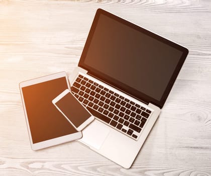 View of a Lapotop in high definition with tablet and mobile on a wood background
