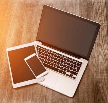 View of a Laptop in high definition with tablet and mobile phone on a wood background