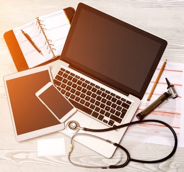 View of a Wood doctor's desk in high definition with laptop, tablet and mobile