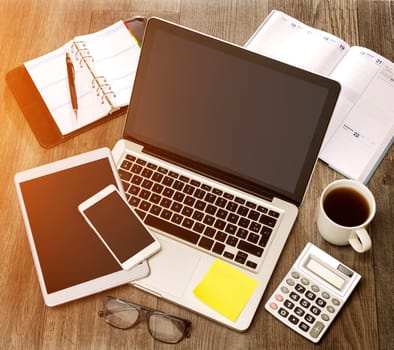 View of a Wood businessman's desk in high definition with laptop, tablet and mobile