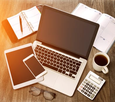 View of a Wood businessman's desk in high definition with laptop, tablet and mobile