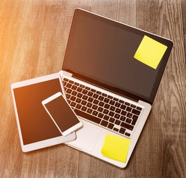 View of a Laptop in high definition with tablet and mobile phone on a wood background