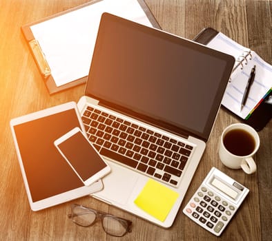 View of a Wood businessman's desk in high definition with laptop, tablet and mobile
