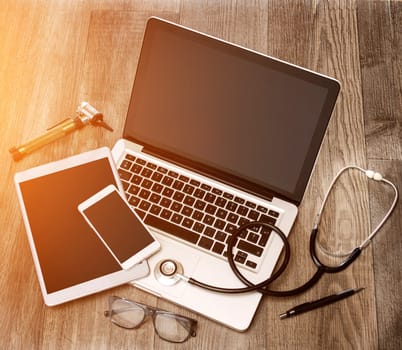 View of a Wood doctor's desk in high definition with laptop, tablet and mobile phone