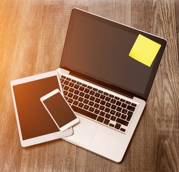 View of a Laptop in high definition with tablet and mobile phone on a wood background