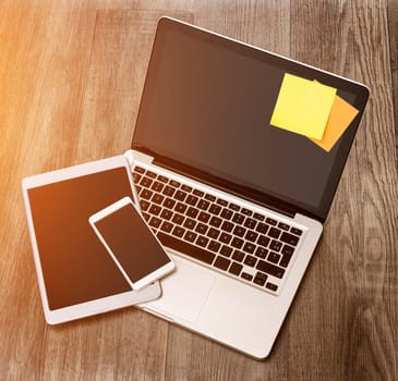 View of a Laptop in high definition with tablet and mobile phone on a wood background