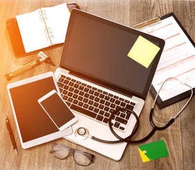 View of a Wood doctor's desk in high definition with laptop, tablet and mobile phone