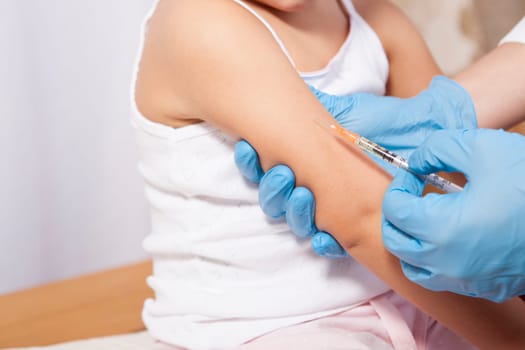 Doctor vaccinating a little girl. Isolated over white background