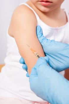 Doctor vaccinating a little girl. Isolated over white background