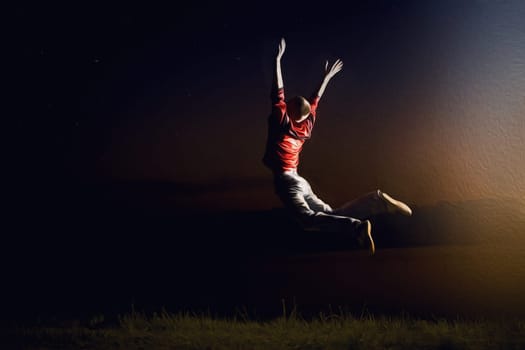 Happy boy, teenager jumping on a night sky background. Outdoor exciting summer vacation, travel life, leisure. Lifestyle freedom concept. Dreamland