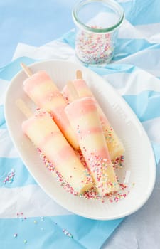 Striped ice cream on the stem with colorful sugar sprinkles