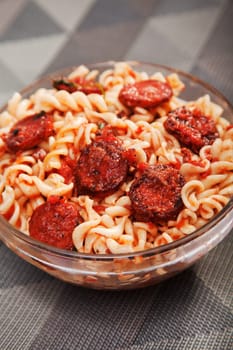 Italian dish - fusilli with sausage, tomato sauce and parmesan, close up