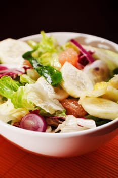 Salad with lettuce, cucumbers and grapefruit, close up
