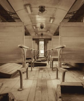 Interior of vintage abandoned passenger train with wooden seat