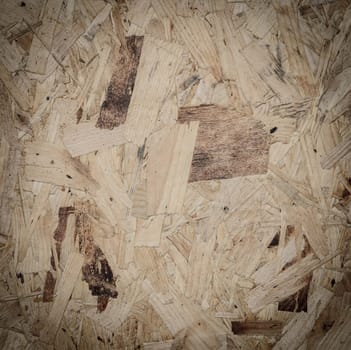 Recycled compressed wood particle board background, texture of oriented strand board (OSB)