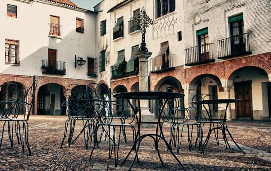 Plaza Chica, Small square of Zafra with pedestal tables, Badajoz, Spain. Vintage filtered
