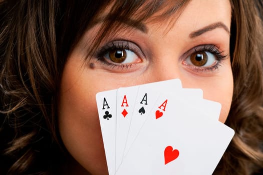Young woman holding four aces in front of her face