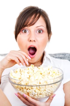 Young woman eating popcorn while watching scary movie isolated on white background