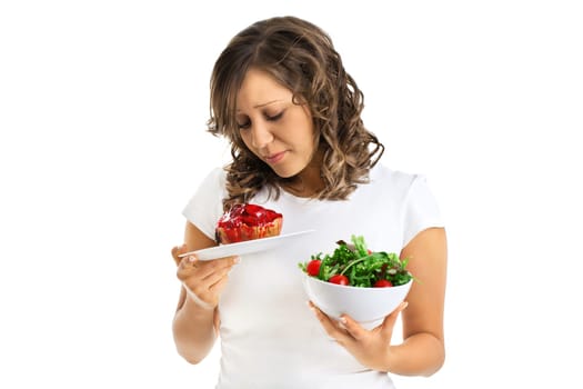 Young woman choosing sweets or healthy eating - one portion of cake and a healthy salad