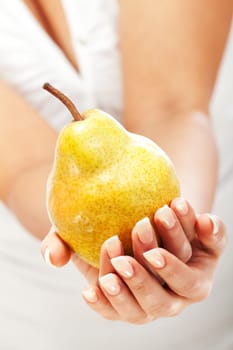Young woman holding pear in her hands, isolated on white