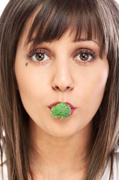 Young woman eating broccoli isolated on white