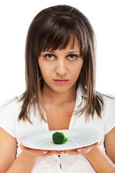 Young woman unhappy for eating healthy food such as broccoli, looking at camera, isolated on white background with copy space