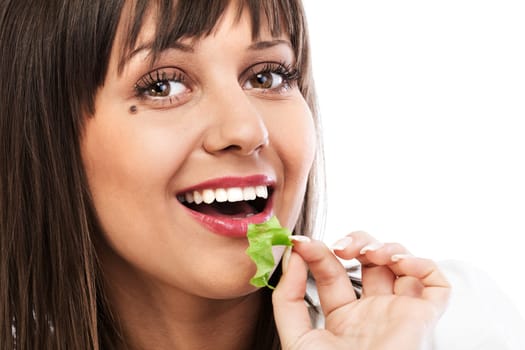 Young woman eating green salad, looking at camera, isolated on white background with copy space