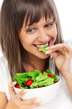 Young woman eating fresh salad with cherry tomatos