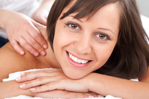Young woman having a classical massage lying on white bed