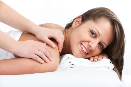 Young woman having a classical massage lying on white bed