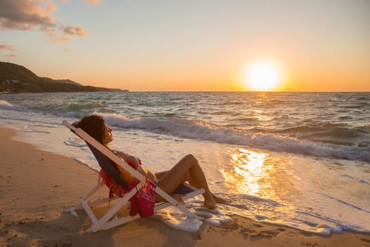 woman lying on the beach near the sea at sunset