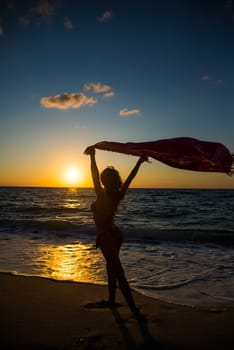 Woman on the beach at sunset
