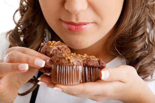Young woman eating chocolate muffin, close up