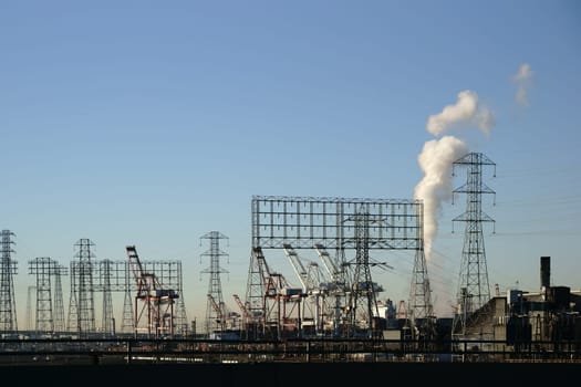 The industrial port of Los Angeles with cranes,power poles and industrial buildings.