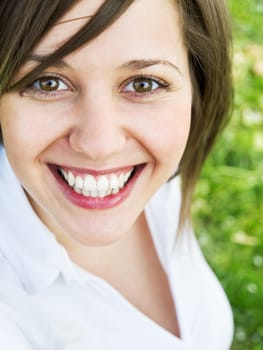Young woman outdoors, looking at camera