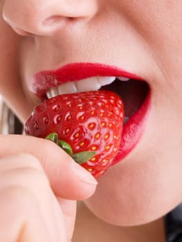 Young woman eating strawberry