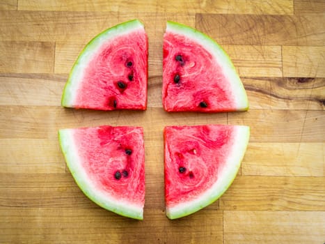 Watermelon slice arranged on a wooden board, raw food fruit stilllife with copyspace